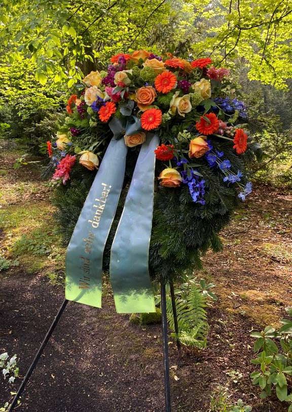 Gärtnerei Vietzen in Ulm | Trauerfloristik Kränze orange Gerbera, gelbe Rosen und blaue Akzente