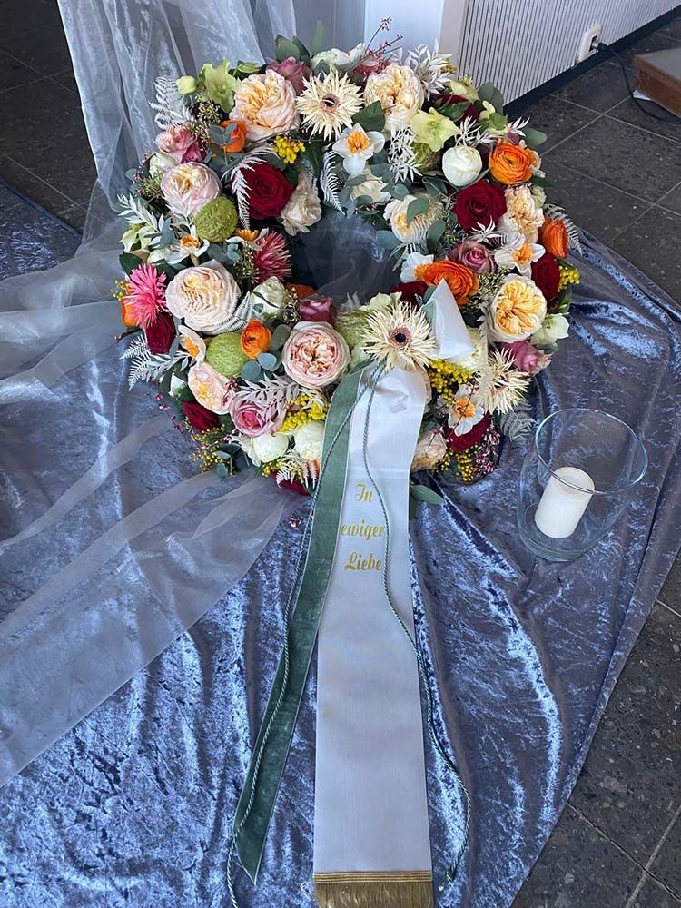 Gärtnerei Vietzen in Ulm | Trauerfloristik Kränze heller Blumenmix mit dunklen Akzenten