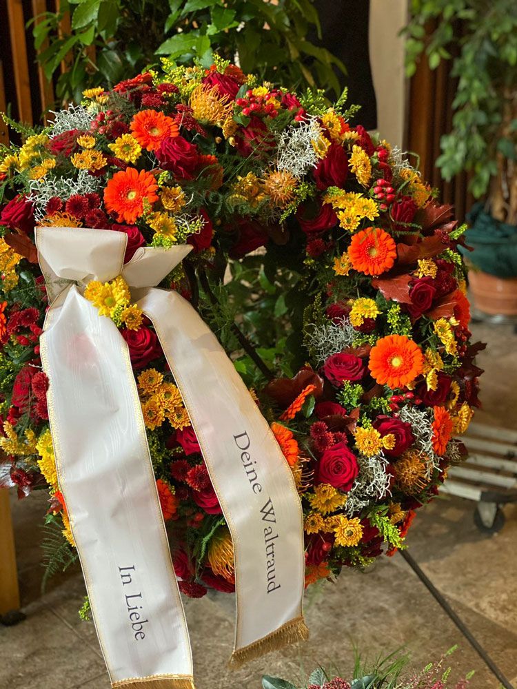 Gärtnerei Vietzen in Ulm | Trauerfloristik Kränze orange-gelb-roter Blumenmix