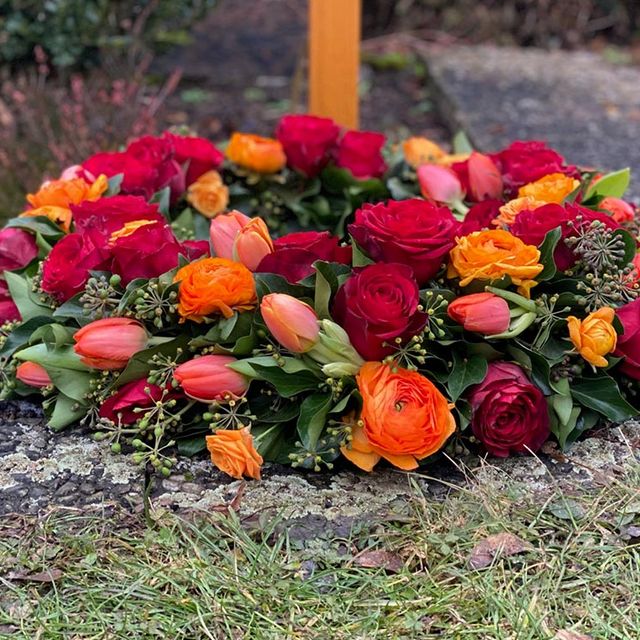 Gaertnerei Vietzen Ulm Trauerfloristik Blumen am Grab für Urnenbestattung rot/orange